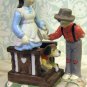 Handpainted bisque figure of boy bringing flowers to girl on porch with dog