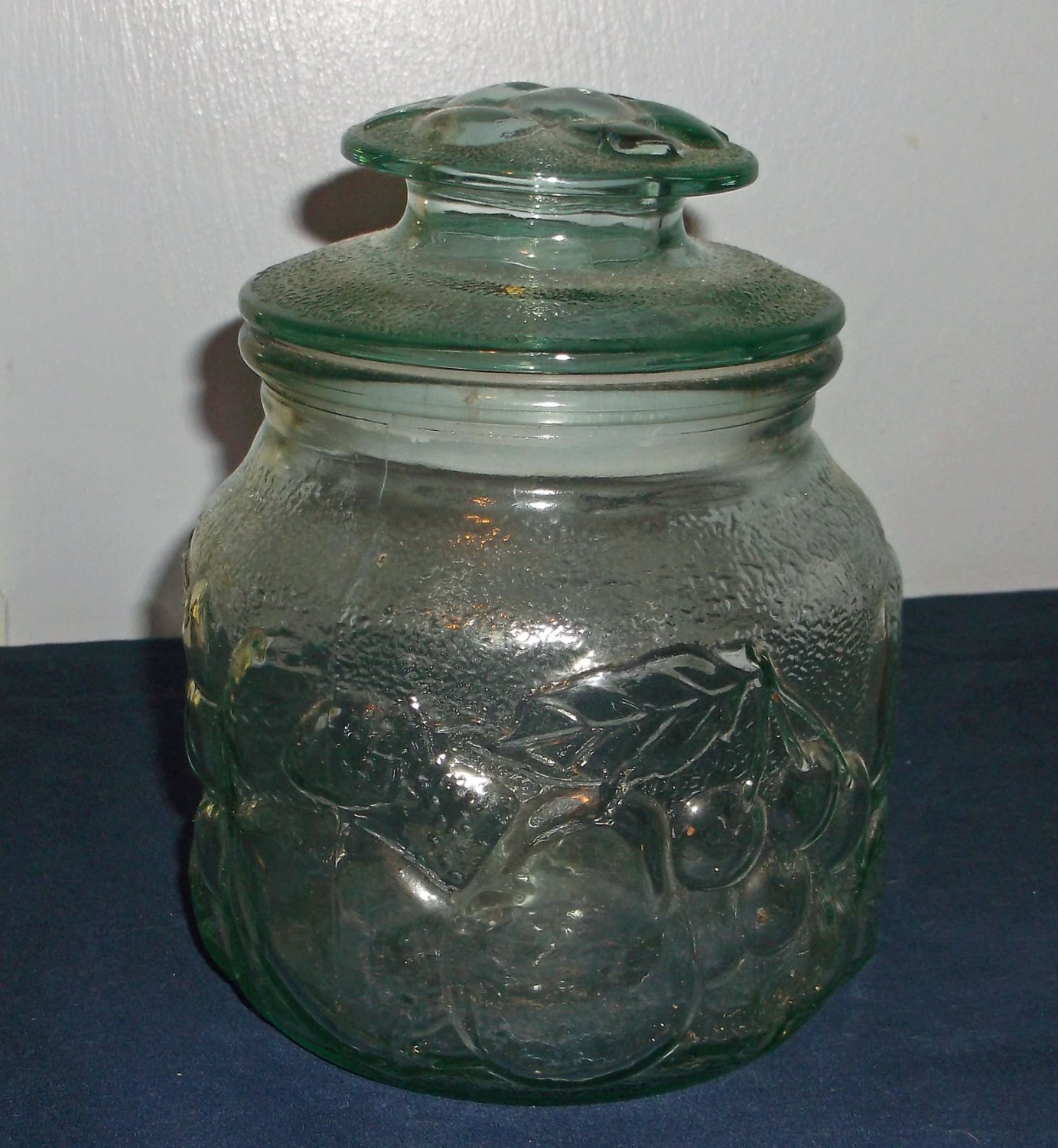 Pale green glass canister with embossed fruit pattern