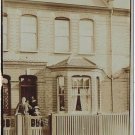 Postcard RPPC Family Dressed In Doorway Of City Home