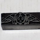 Angry looking face with wings metal printing block unkown maker
