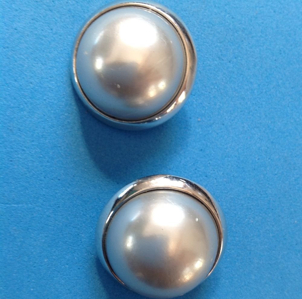 Richelieu silver clip earrings with white center 1" in diameter.