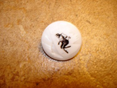 Mother of pearl button with black devil picture.