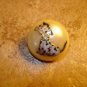 Dome shape plastic button with sitting dog.