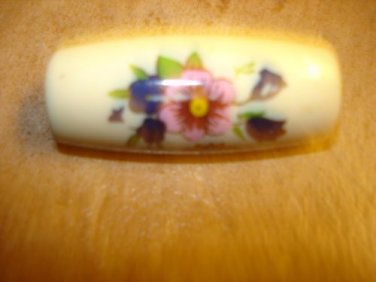 Large plastic oblong button with flowers.