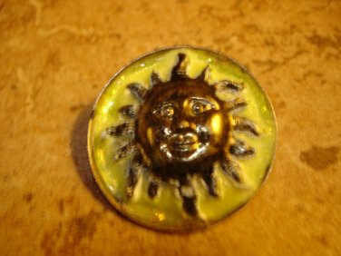 Large metal button with smiling sun.