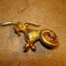 Gold tone metal button in shape of ram goat and rhinestones.