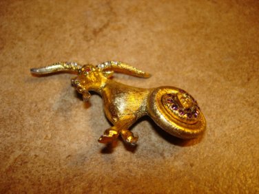 Gold tone metal button in shape of ram goat and rhinestones.
