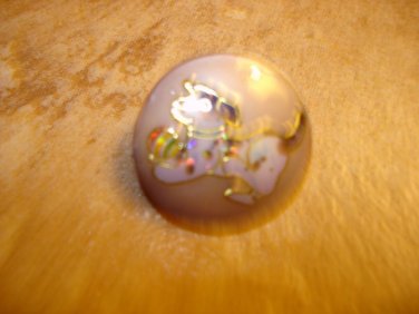 Plastic button with dog playing with ball.