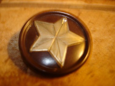 Large plastic button with metal star and tiny rhinestone.