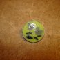 Signed silver metal button with green flower.