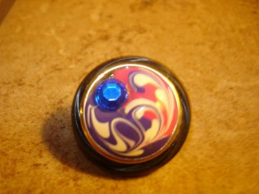 Art nouveau style plastic button with blue rhinestone.