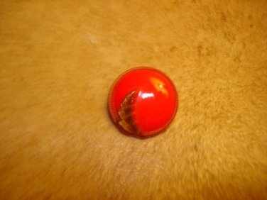 Old red glass button with gold leaf.