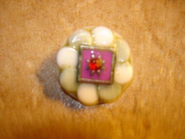 White plastic button with red rhinestone.