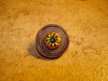 Old plastic button with blue rhinestone.