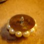 Large button with white pearls and metal back.