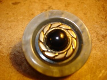 Large plastic button with black glass bead.