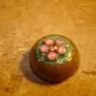Dome shape plastic button with pink rhinestones and metal back.