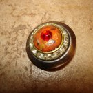 Large vintage metal button with white and red rhinestones.