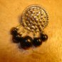 Silver metal button with black beads.