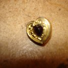 Heart shape gold metal button with garnet color stone.