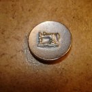 Old gold metal button with silver metal sewing machine. Old gold metal button with silver metal sewing machine.
