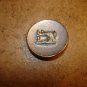 Old gold metal button with silver metal sewing machine.