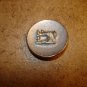 Old gold metal button with silver metal sewing machine.