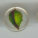 Set of 3 plastic buttons with green leaf.