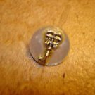 Mother of pearl button with silver key.