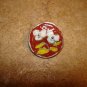 Signed silver metal button with white flower.