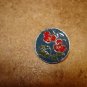 Signed silver metal button with red flower.