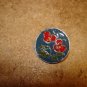 Signed silver metal button with red flower.