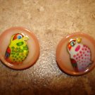 Set of 2 pink plastic buttons with colorful birds. Set of 2 pink plastic buttons with colorful birds.