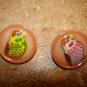 Set of 2 pink plastic buttons with colorful birds.