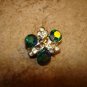 Delicate silver metal button with green rhinestones.