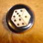 Black plastic button with dice.