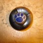Black plastic button with bear paw.