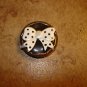 Large gold metal button with large bow.
