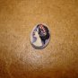 Oval plastic button with Roman lady bust.