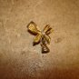 Gold metal ribbon button with bell and rhinestone.