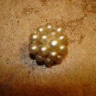 Small metal button with white pearls.