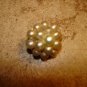 Small metal button with white pearls.