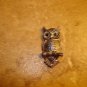 Silver tone metal button in shape of owl sitting on branch.
