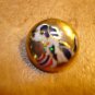 Dome shape gold metal button with dog and ball.