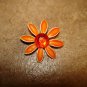 Metal flower button with large red rhinestone.