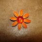 Metal flower button with large red rhinestone.