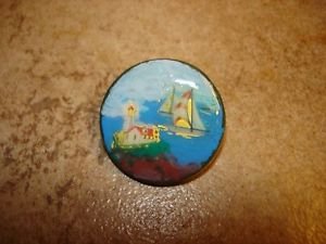 Large painted plastic button with lighthouse and sailboat.