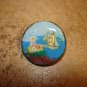 Large painted plastic button with lighthouse and sailboat.