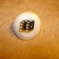 Mother of pearl button with dice.
