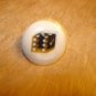 Mother of pearl button with dice.